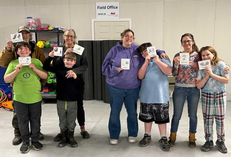 4 kids stand with their parents in a gym