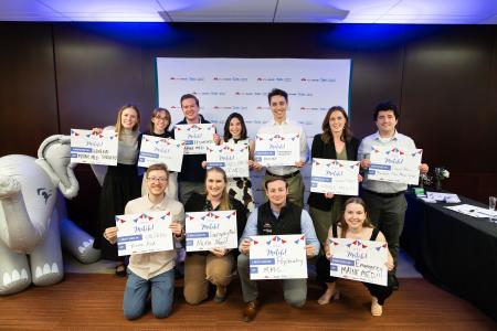 A group of medical students smiling and holding up signs celebrating their "match day"