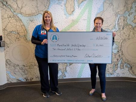 Letitia Stover and Deb Violette holding a large presentation check for a $10,000 grant award