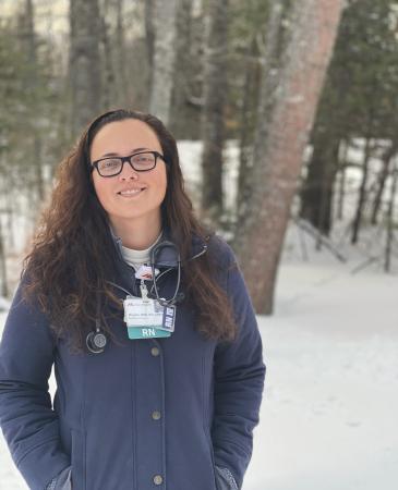 Megan Harvey standing outside in the snow in front of the woods