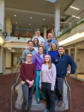 members of the pulmonary critical care fellowship team standing on a staircase in a large open lobby