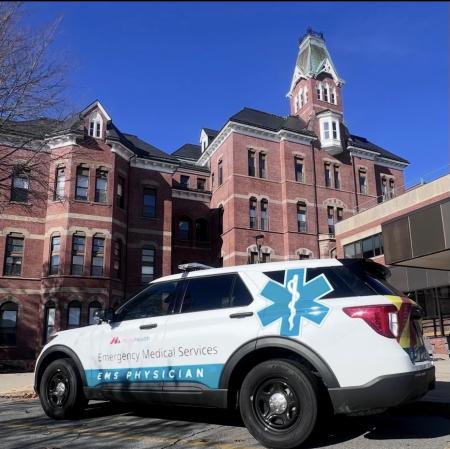 A white MaineHealth Emergency Medical Services EMS Physician SUV parked in front of MaineHealth Maine Medical Center in Portland