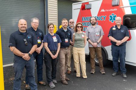 members of the MaineHealth IFT team standing together next to an ambulance