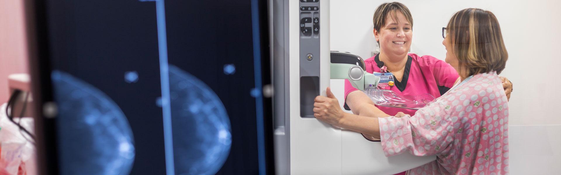 A mammography care team member assists a patient during a mammography