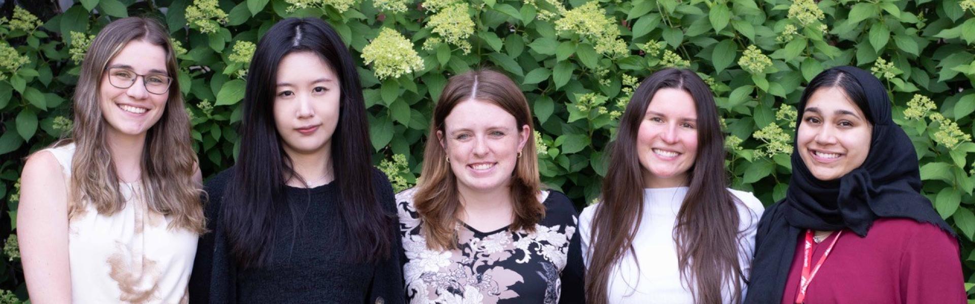 five pharmacy residents standing together outside in front of a green hedge