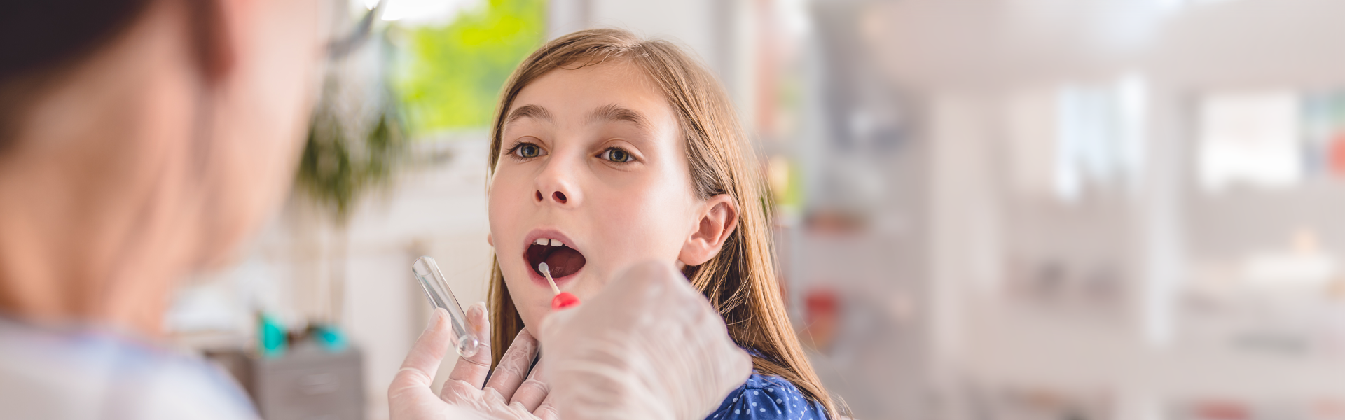 A patient is swabbed for a diagnostic test at an urgent care location.