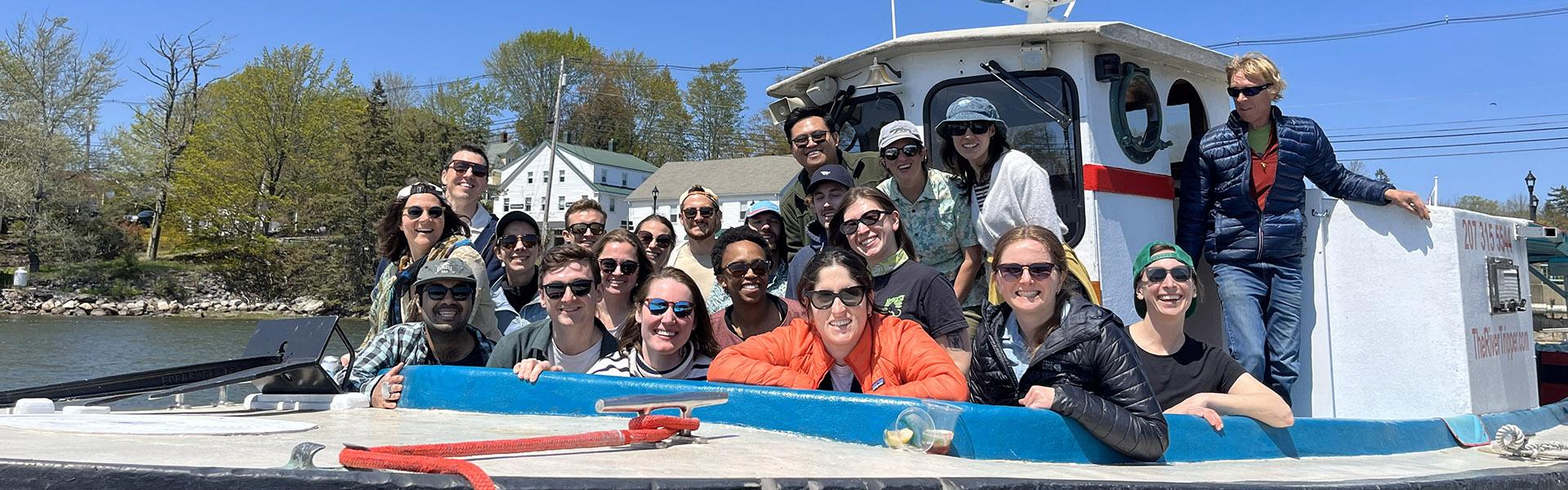 a group of adults, general psychiatry residents, smiling and happy together on a boat on a sunny day