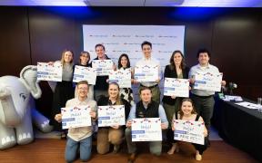 A group of medical students smiling and holding up signs celebrating their "match day"