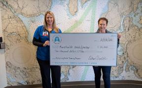 Letitia Stover and Deb Violette holding a large presentation check for a $10,000 grant award