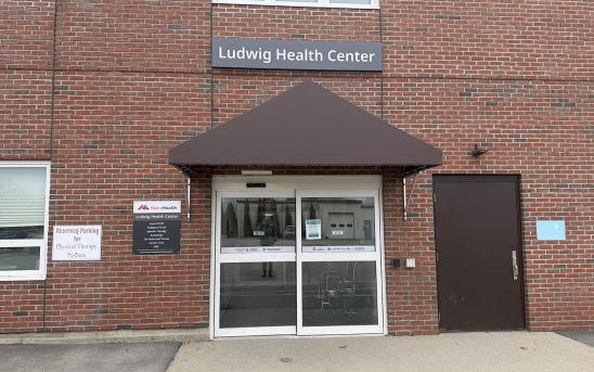Exterior of 116 Northport Ave in Belfast featuring the rear entrance with a dark awning over the door