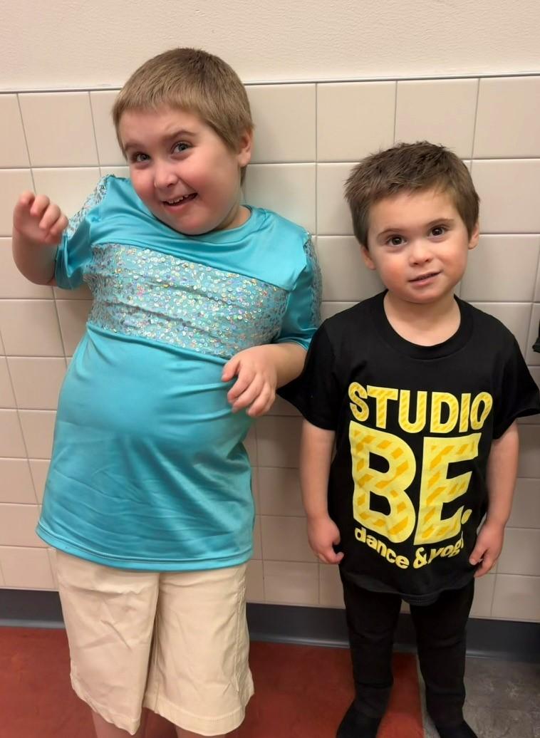 Two young boys standing together in a hallway