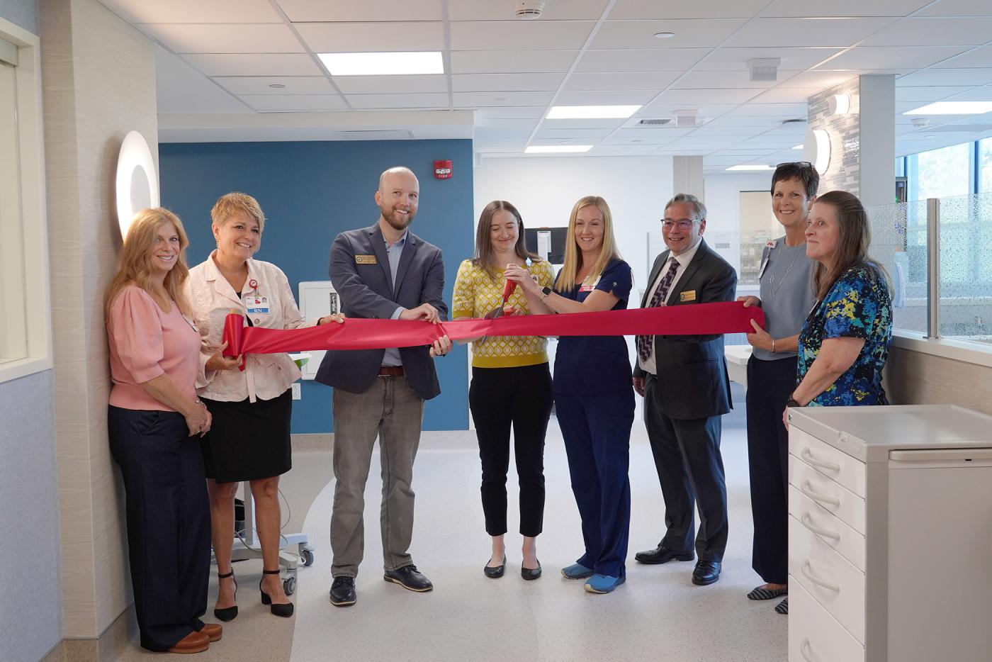 MaineHealth Lincoln Hospital clinicians and leaders stand together in a group behind a large red ribbon