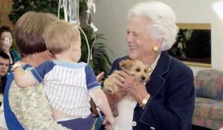 Former first lady Barbara Bush holds a puppy while speaking with patients and families
