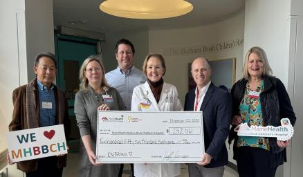 a group of adults presenting an oversized check to the MHBBCH