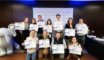 A group of medical students smiling and holding up signs celebrating their "match day"