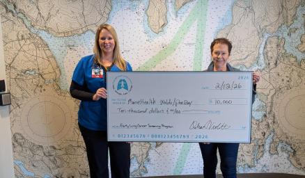 Letitia Stover and Deb Violette holding a large presentation check for a $10,000 grant award