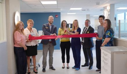 MaineHealth Lincoln Hospital clinicians and leaders stand together in a group behind a large red ribbon