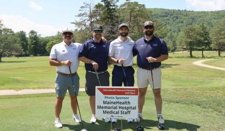 four adults, members of team heb engineers, posing together on the greens during the Memorial Hospital golf tournament
