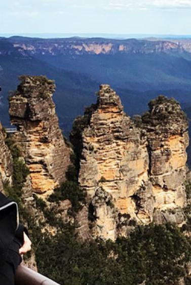 Smiling young woman looking at an arid canyon and rock formation